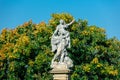 Classic statue in a park with blue sky and tree on background